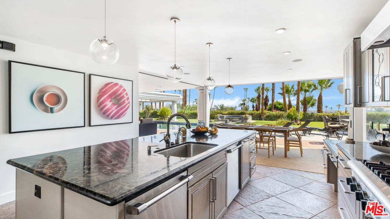 70375 Calico Road Rancho Mirage, CA 92270 - Photo 11 of 46 a kitchen with stainless steel appliances granite countertop a sink a stove and a wooden floors