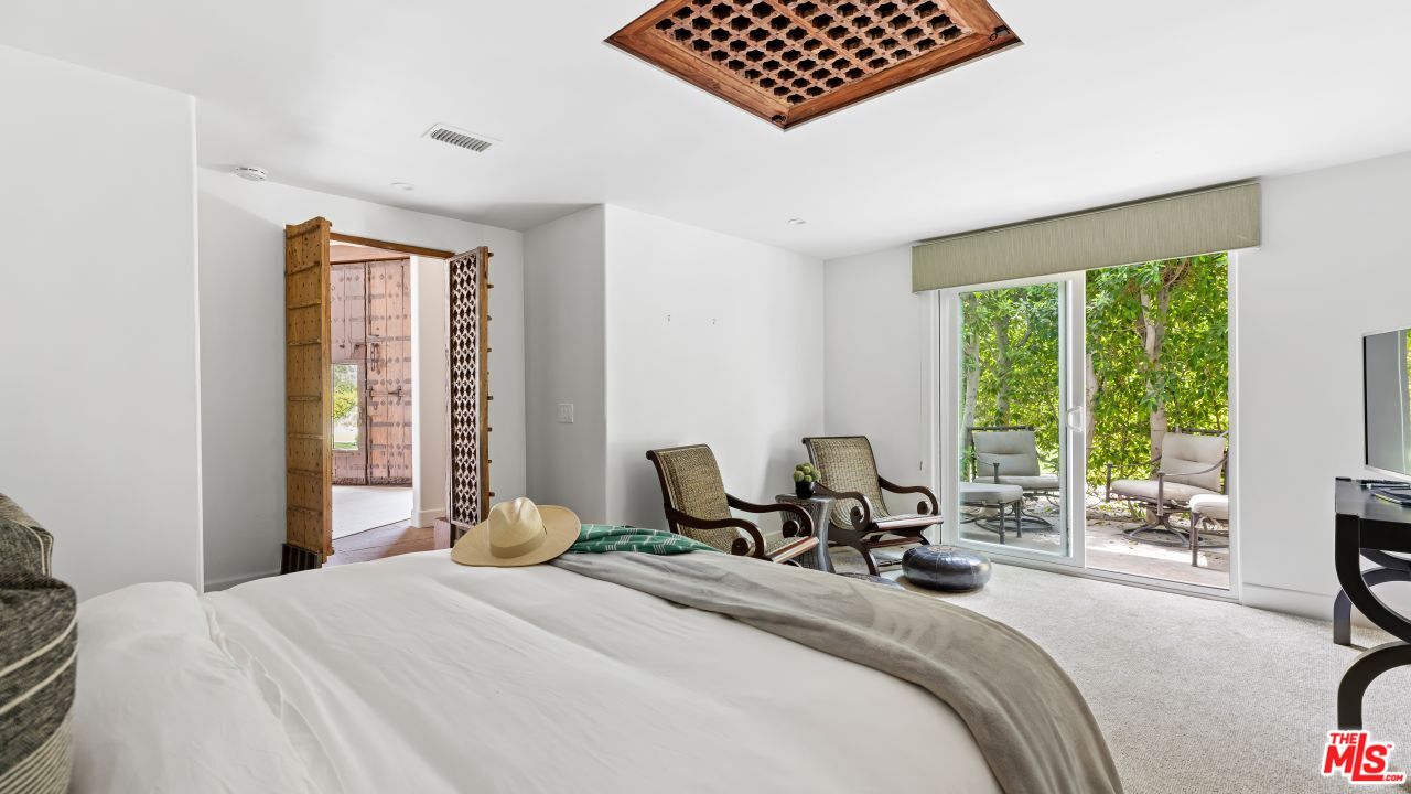 70375 Calico Road Rancho Mirage, CA 92270 - Photo 28 of 46 a bedroom with a bed a large window and a couch