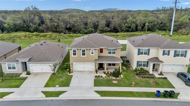 a aerial view of a house with a yard and a large tree