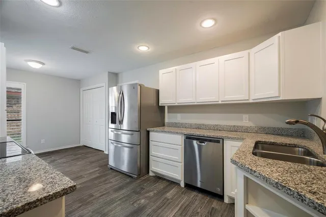 a kitchen with a sink a refrigerator and cabinets