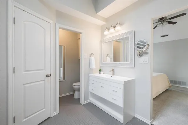 a bathroom with a double vanity sink mirror and toilet