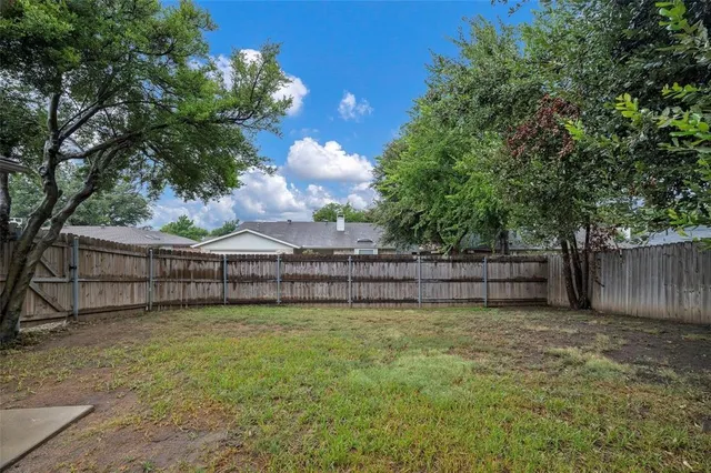 a view of a yard with wooden fence