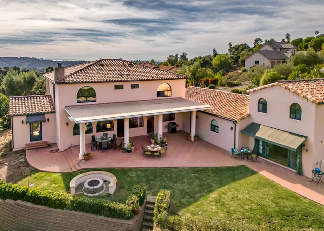 a kitchen with stainless steel appliances granite countertop a stove a refrigerator a kitchen island a dining table and chairs with wooden floor