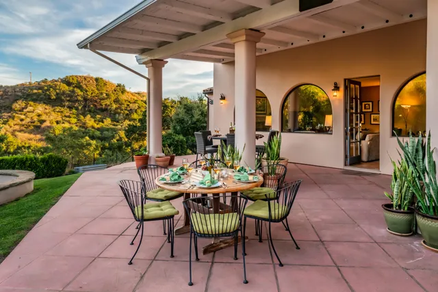 a view of a patio with table and chairs potted plants with wooden floor and fence