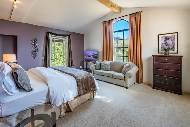 a living room with furniture a chandelier and a large window
