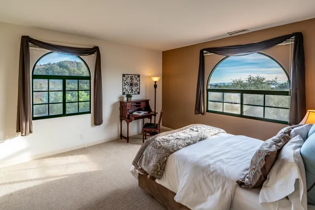 a bedroom with bed and a large window