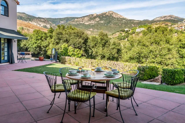 a front view of a house with a yard and potted plants