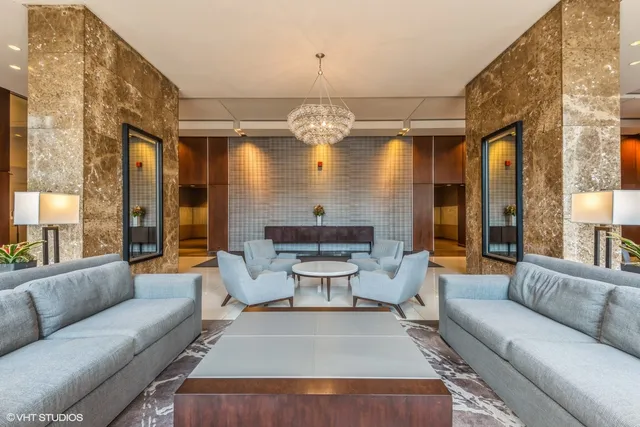 a living room with furniture chandelier and a large window