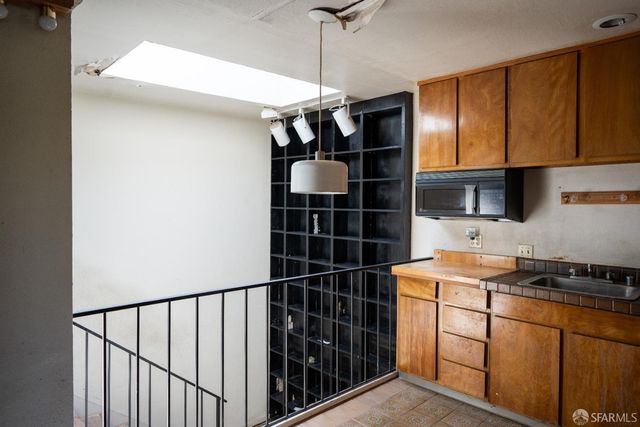 a kitchen with a refrigerator a stove and wooden floor
