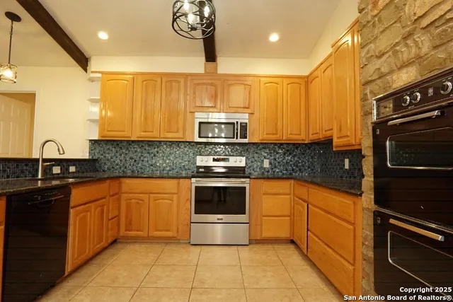 a kitchen with stainless steel appliances granite countertop a stove sink and cabinets