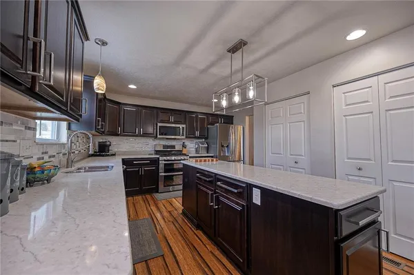a large kitchen with stainless steel appliances lots of counter space and a sink