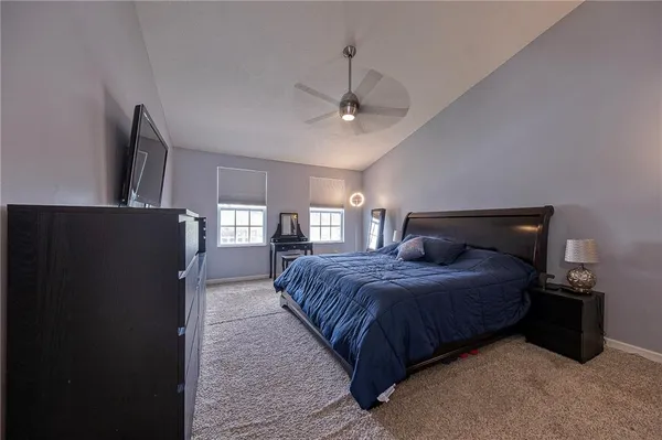 a bedroom with a bed a flat screen tv and dresser
