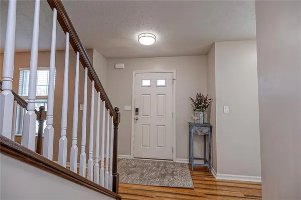 a view of a hallway with wooden floor and staircase