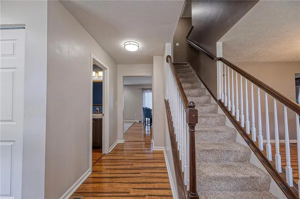 a view of a hallway with wooden floor and stairs