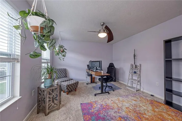 a living room with furniture flowers and a window