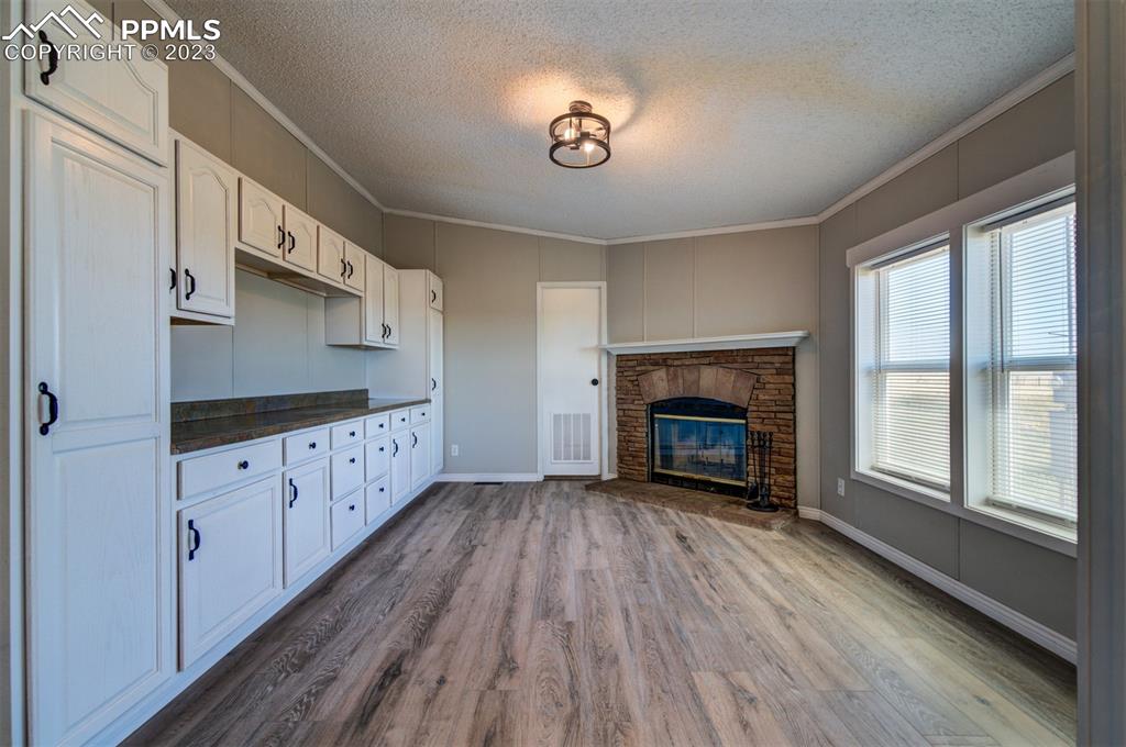 33220 Fossinger Road Yoder, CO 80864 - Photo 10 of 21 a view of an empty room with wooden floor fireplace and a window