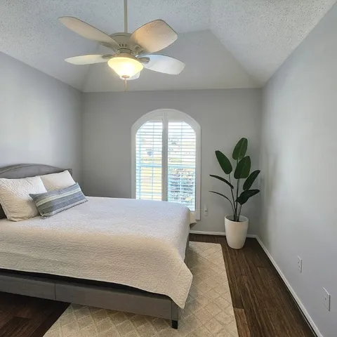 a bedroom with a bed and a potted plant