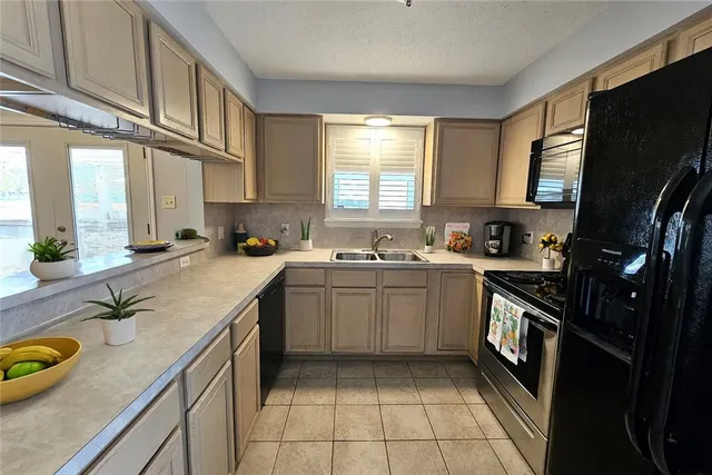 a kitchen with a sink a stove cabinets and a window