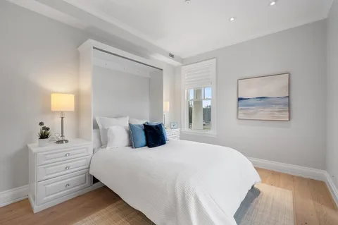 a bedroom with a bed and a lamp on dresser