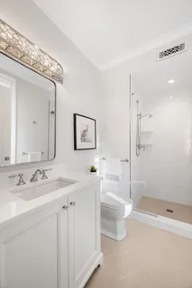 a bathroom with a double vanity sink toilet and shower
