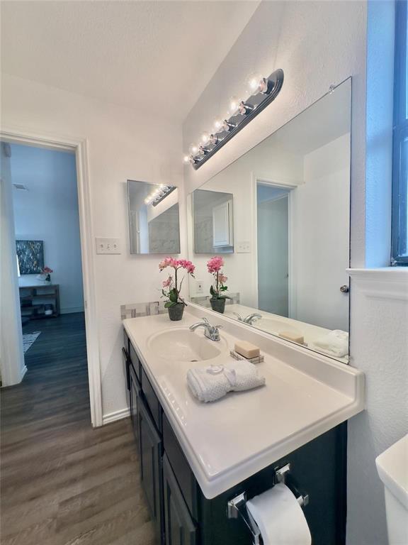 7340 Skillman Street, Unit 405 Dallas, TX 75231 - Photo 7 of 18 Double vanity with integrated sinks, dark wood-finish cabinetry, and chrome fixtures