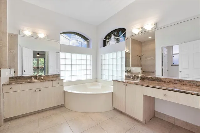 a large spacious bathroom with a granite countertop tub sink and mirror