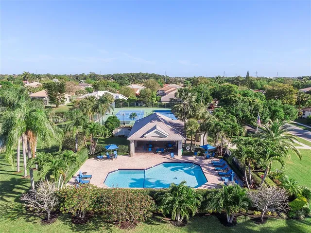 a view of a big house with a big yard and large trees