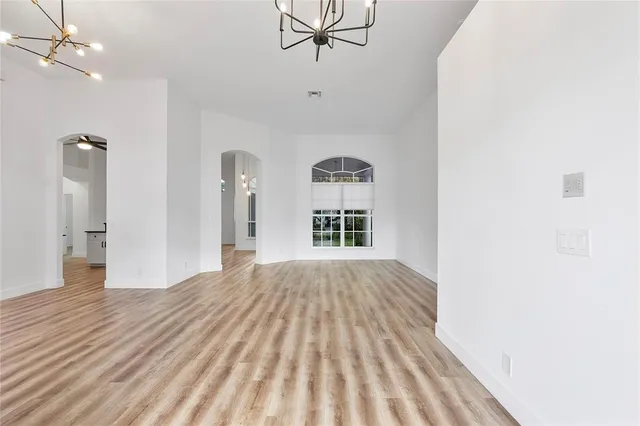 a view of empty room with wooden floor and ceiling fan