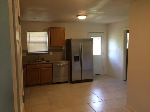 a kitchen with stainless steel appliances granite countertop a refrigerator and a stove