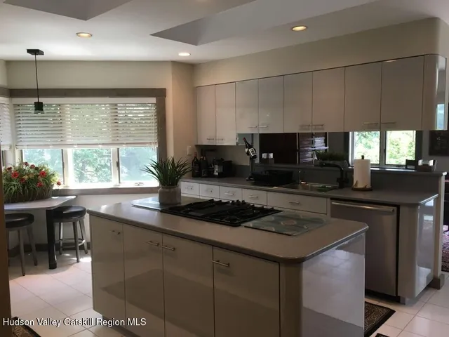 a kitchen with stainless steel appliances granite countertop a sink a stove a microwave a refrigerator and cabinets