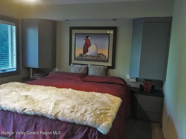 a bedroom with a bed and a painting on the wall