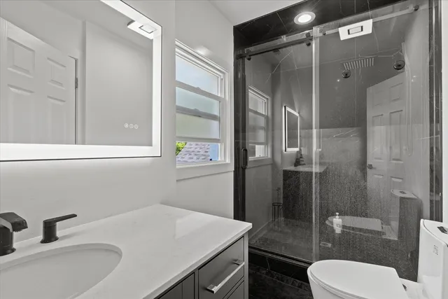 a bathroom with a sink toilet and shower