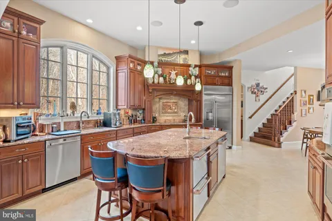 a kitchen with stainless steel appliances granite countertop a refrigerator and a stove top oven