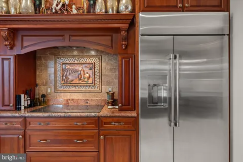 a kitchen with stainless steel appliances granite countertop a refrigerator and a stove top oven