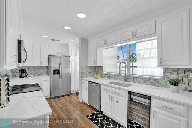 a kitchen with stainless steel appliances granite countertop a sink a stove a microwave and cabinets