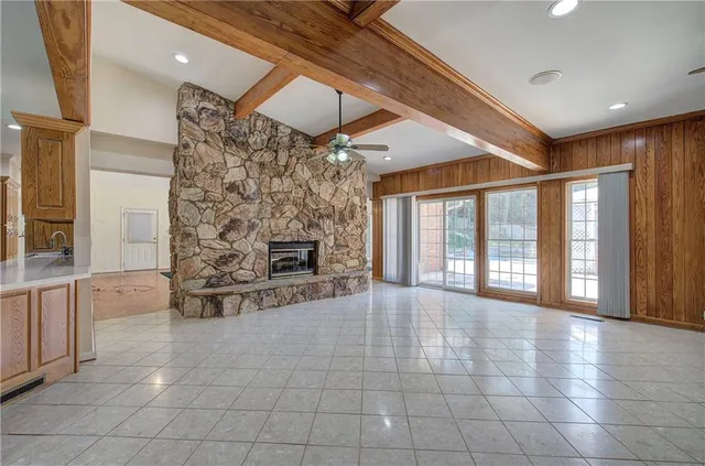 a view of an empty room with a fireplace and a window