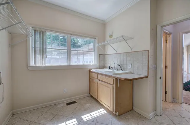 a utility room with a sink and washing machine