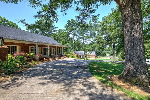 a view of a house with backyard and a tree