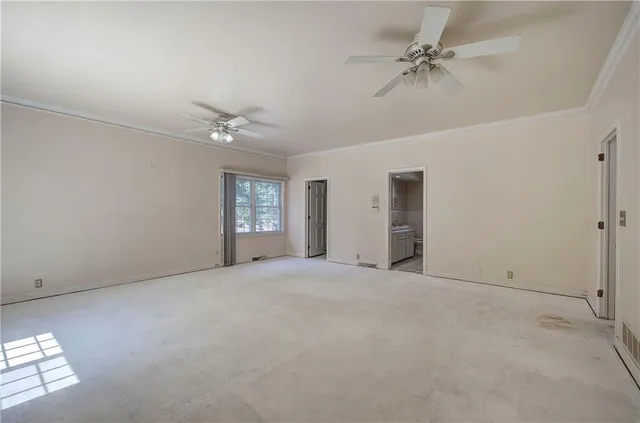 an empty room with fan and windows