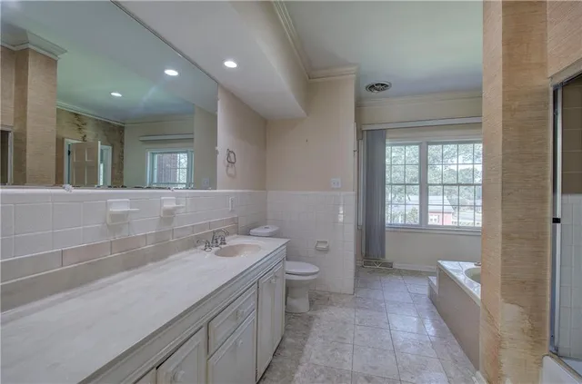 a bathroom with a granite countertop sink a toilet and shower