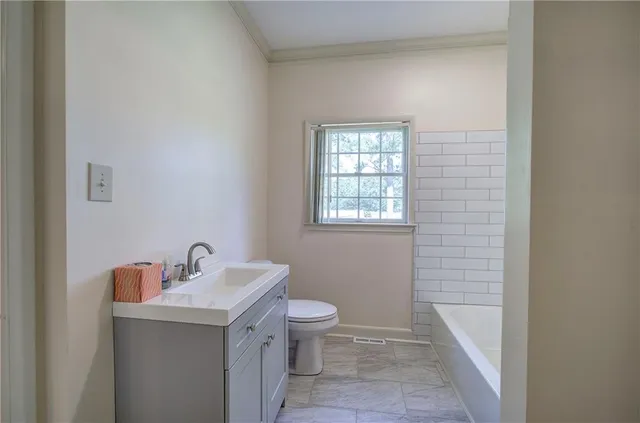 a bathroom with a sink a toilet and a window