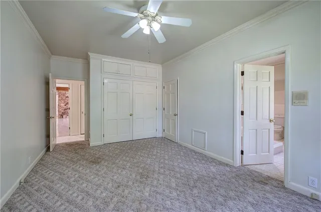 an empty room with closet and a chandelier fan