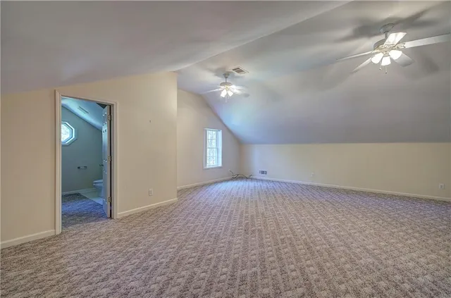 wooden floor in an empty room with a chandelier fan