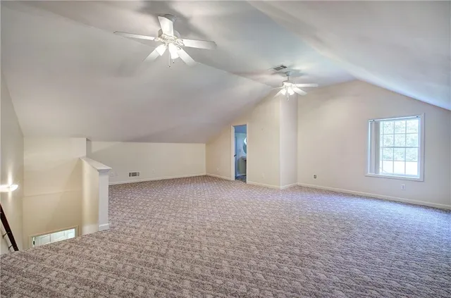 a view of a big room with chandelier fan and windows