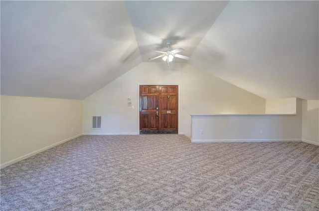 an empty room with fan and windows