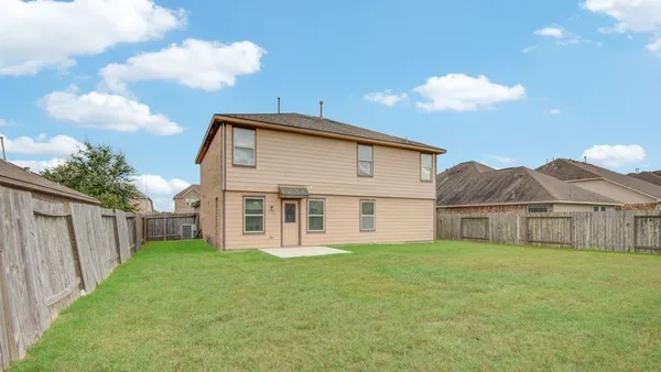 a view of a house with a yard and fence