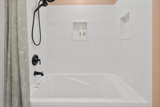 a bathroom with a bath tub with a shower