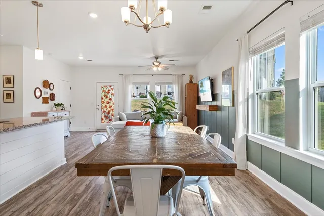a view of a dining room with furniture a chandelier and wooden floor