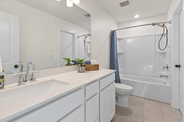a bathroom with a granite countertop sink a toilet and shower