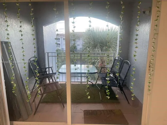 a view of a porch with chairs and backyard